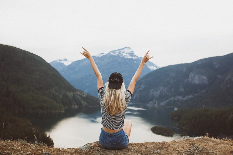 A girl with wide open arms feels free in the nature.